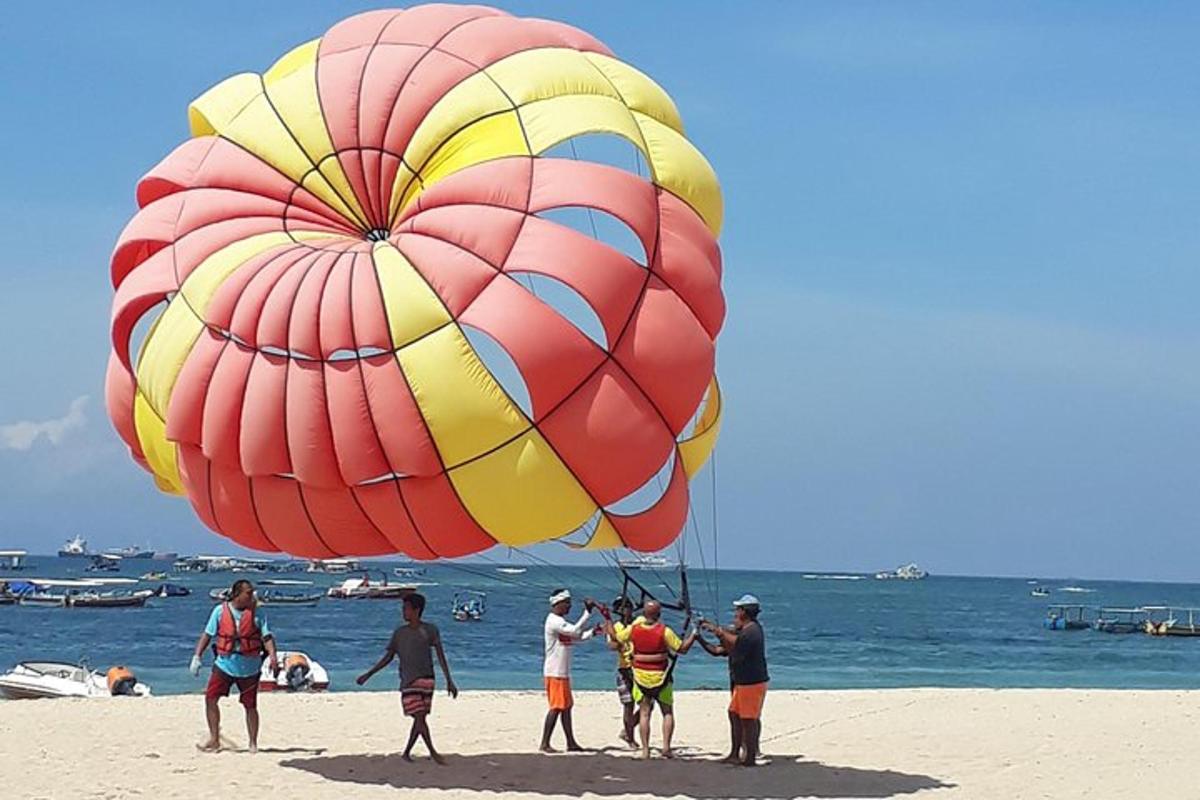 sekumpulan manusia di pantai dengan layang-layang yang besar
