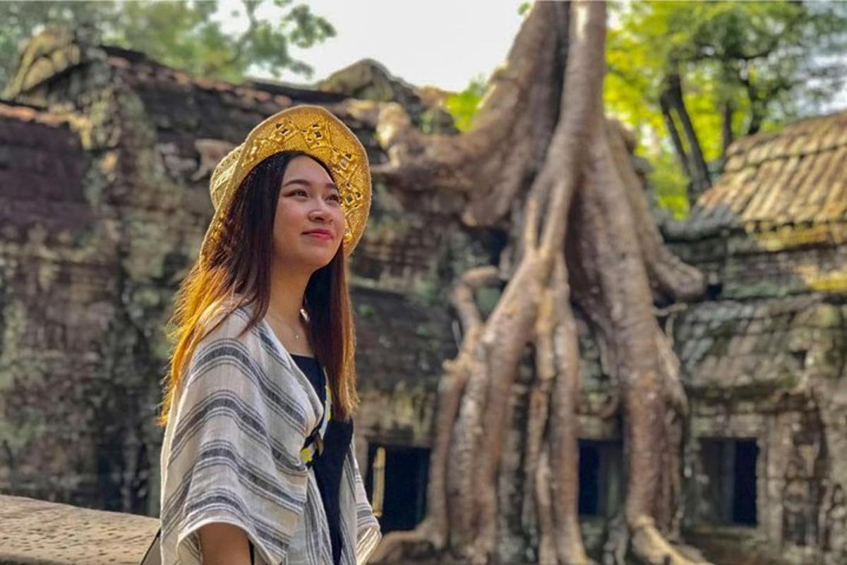một người phụ nữ đội mũ đứng trước một tòa nhà
