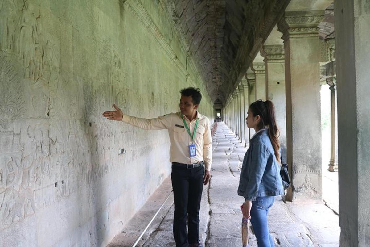 một người đàn ông và một người phụ nữ đứng cạnh một bức tường