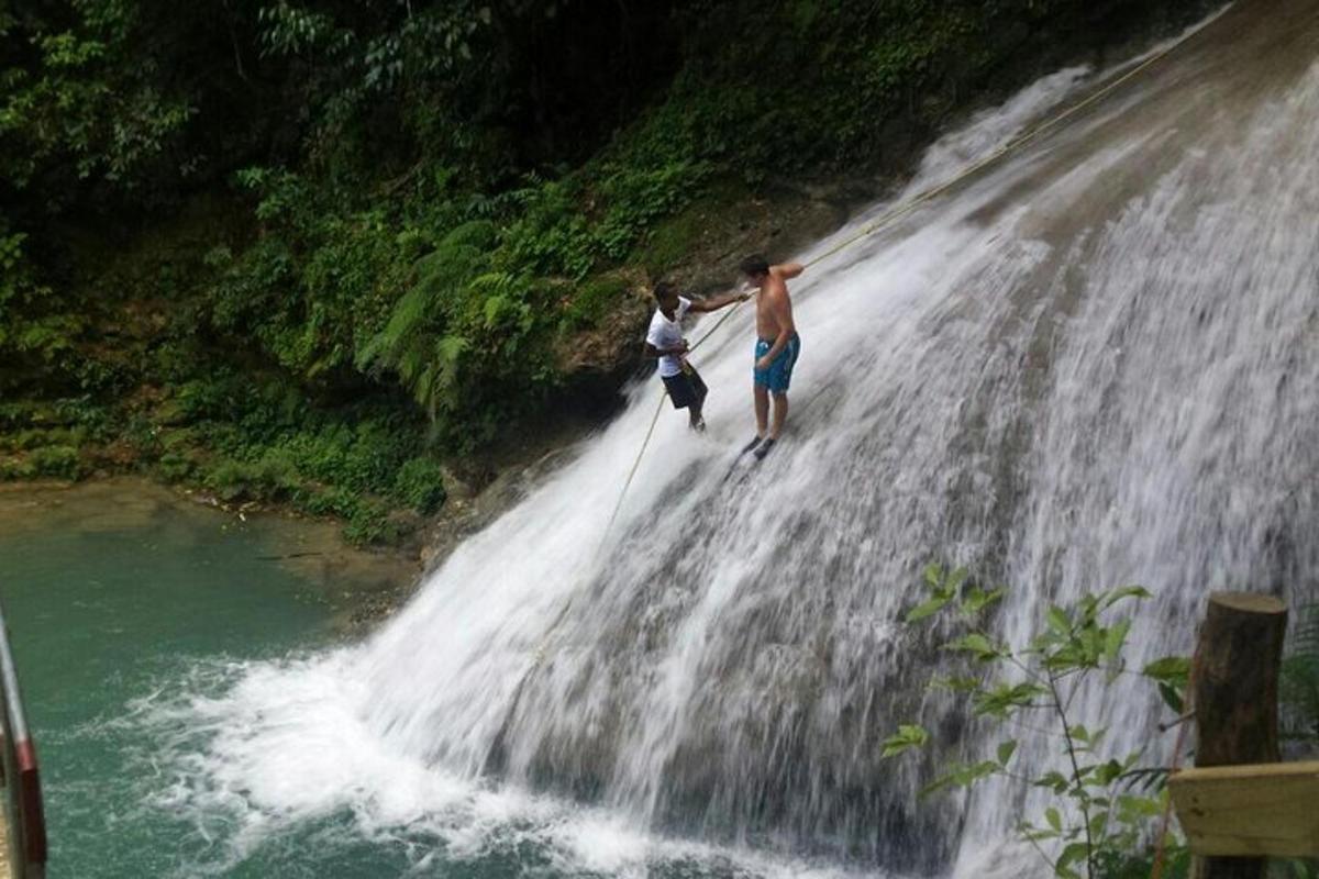 two people standing on top of a waterfall