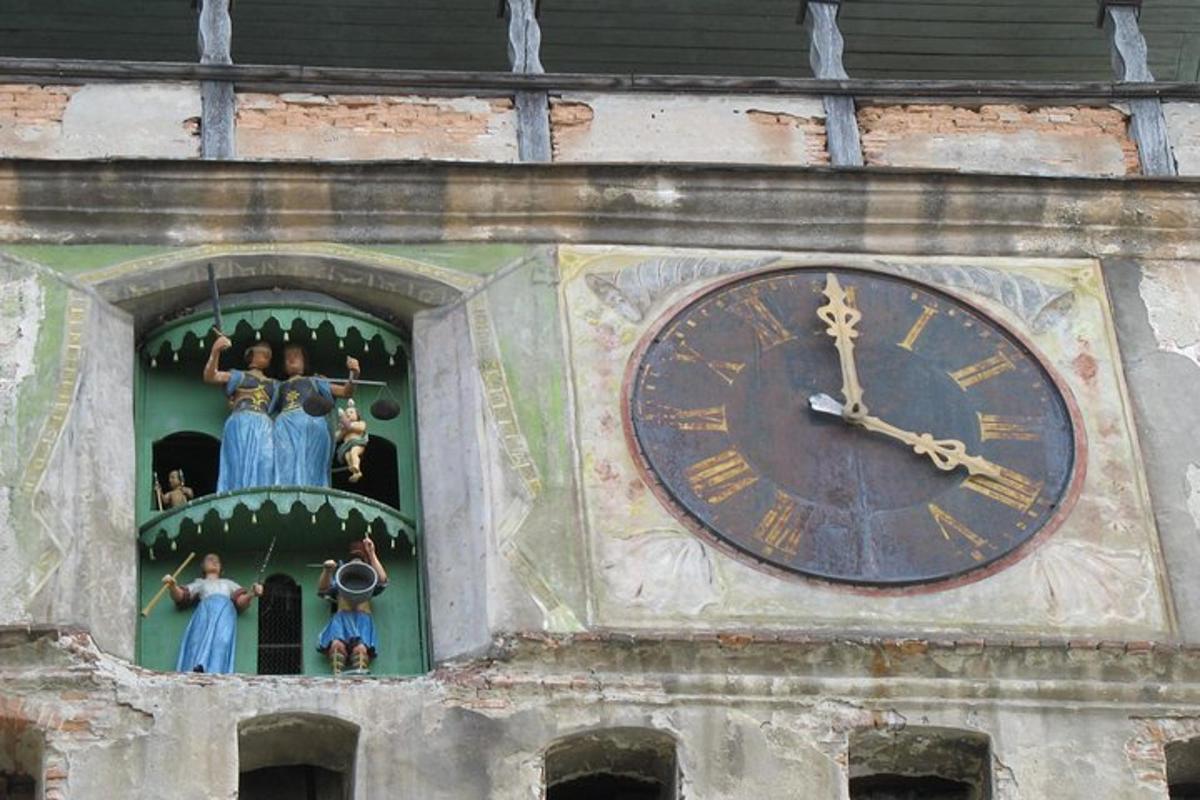 a clock on the side of a tower with figurines