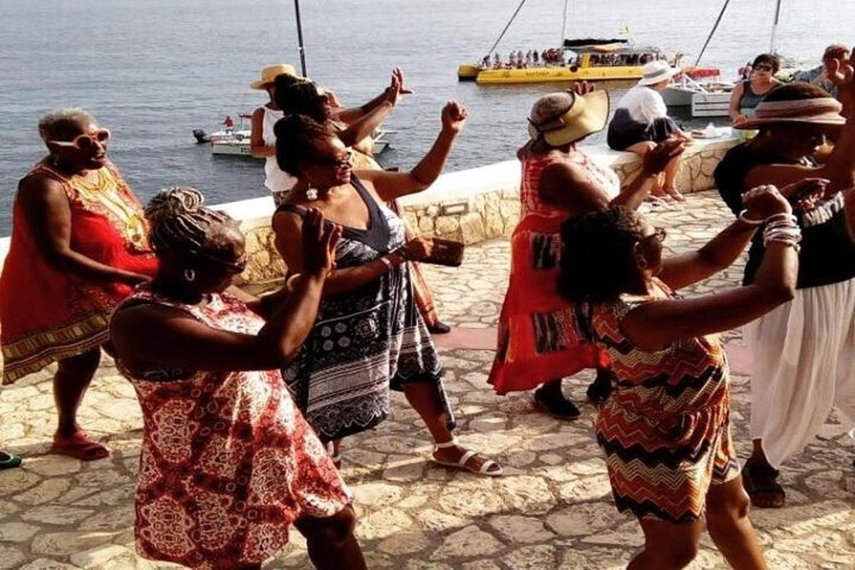 un gruppo di persone che ballano in riva all'acqua