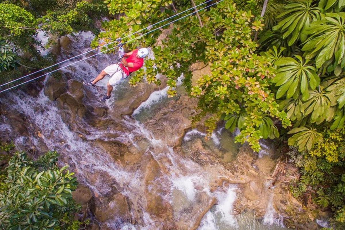 muž kráčející po zip line nad vodopádem
