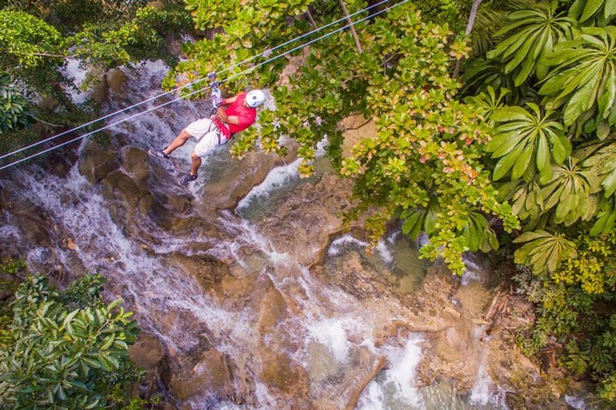 un hombre en una tirolina sobre una cascada