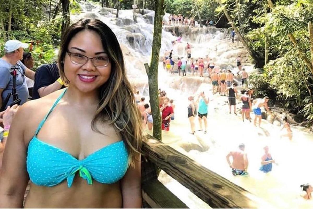 a woman in a blue bikini standing in front of a waterfall