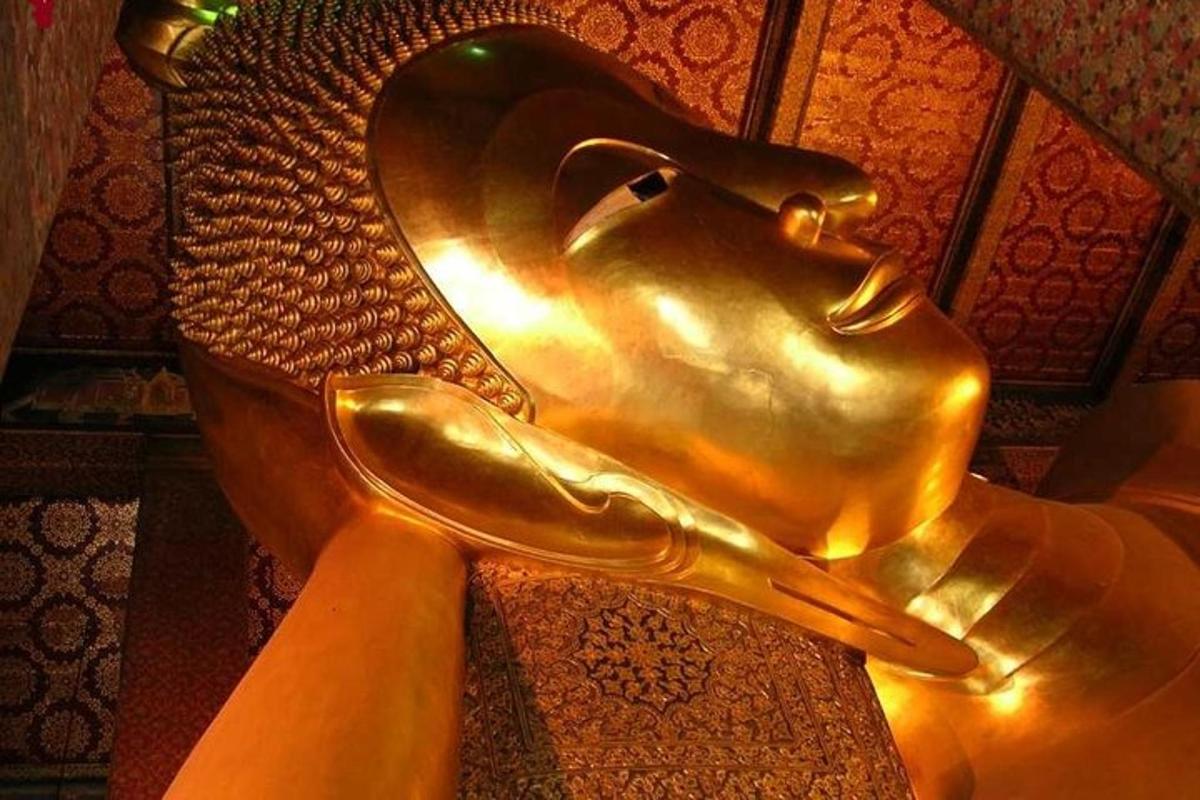 una statua in bronzo di una donna seduta su una sedia