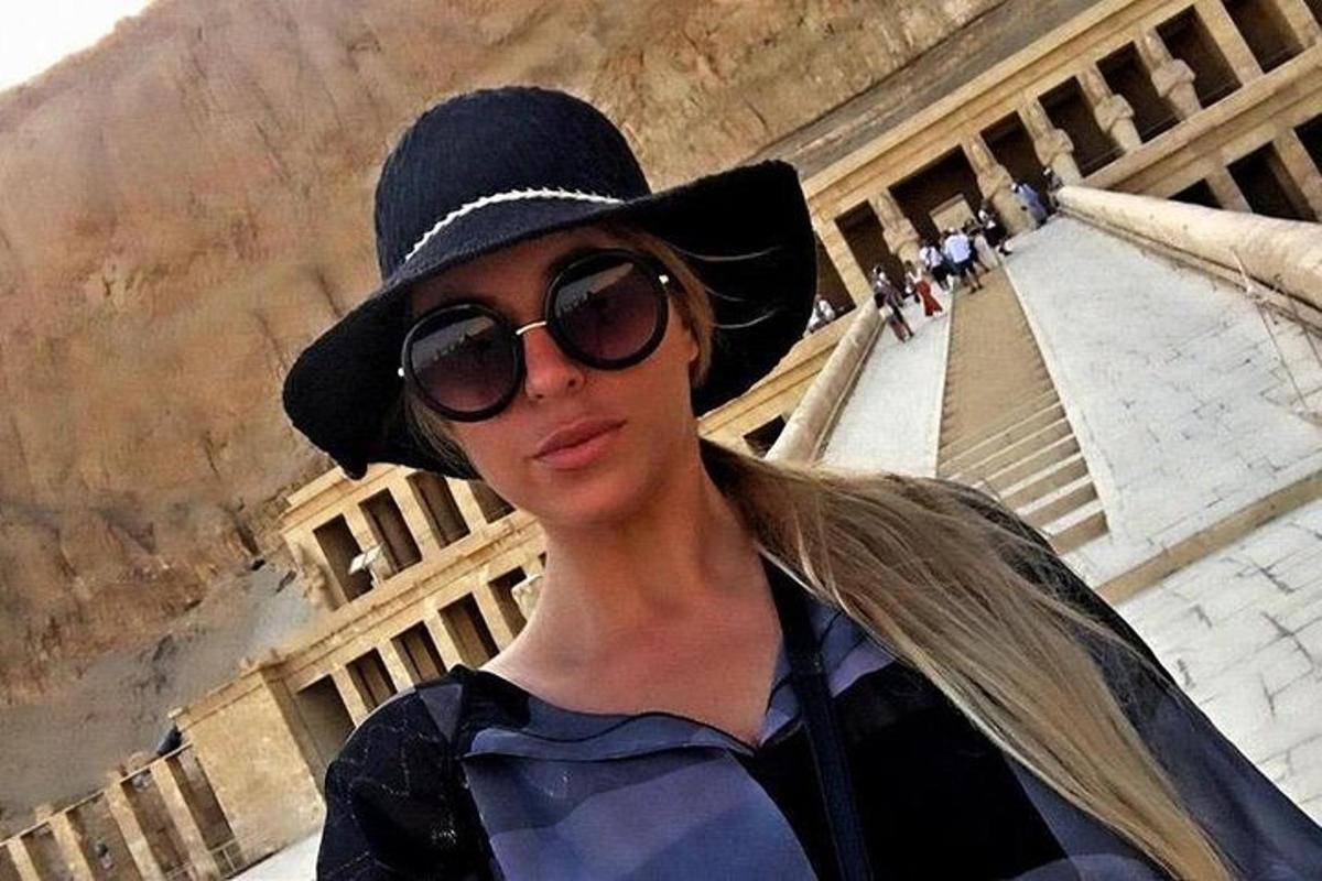 жена са шеширом и наочарама за сунце испред пирамиде