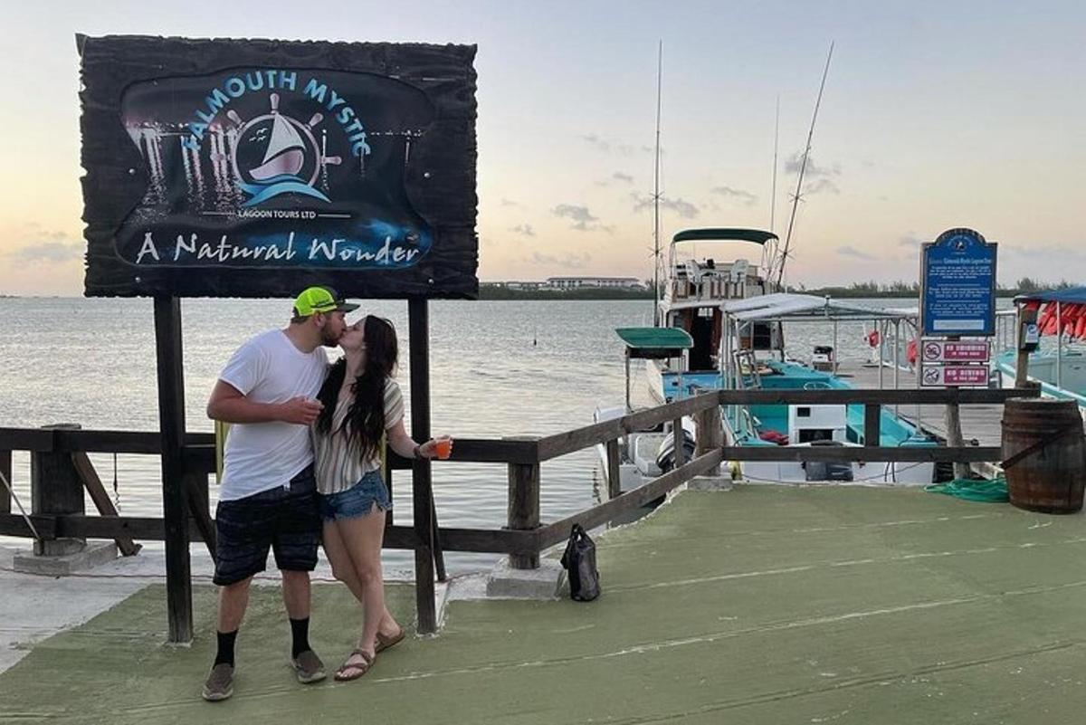 a man and a woman kissing on a dock