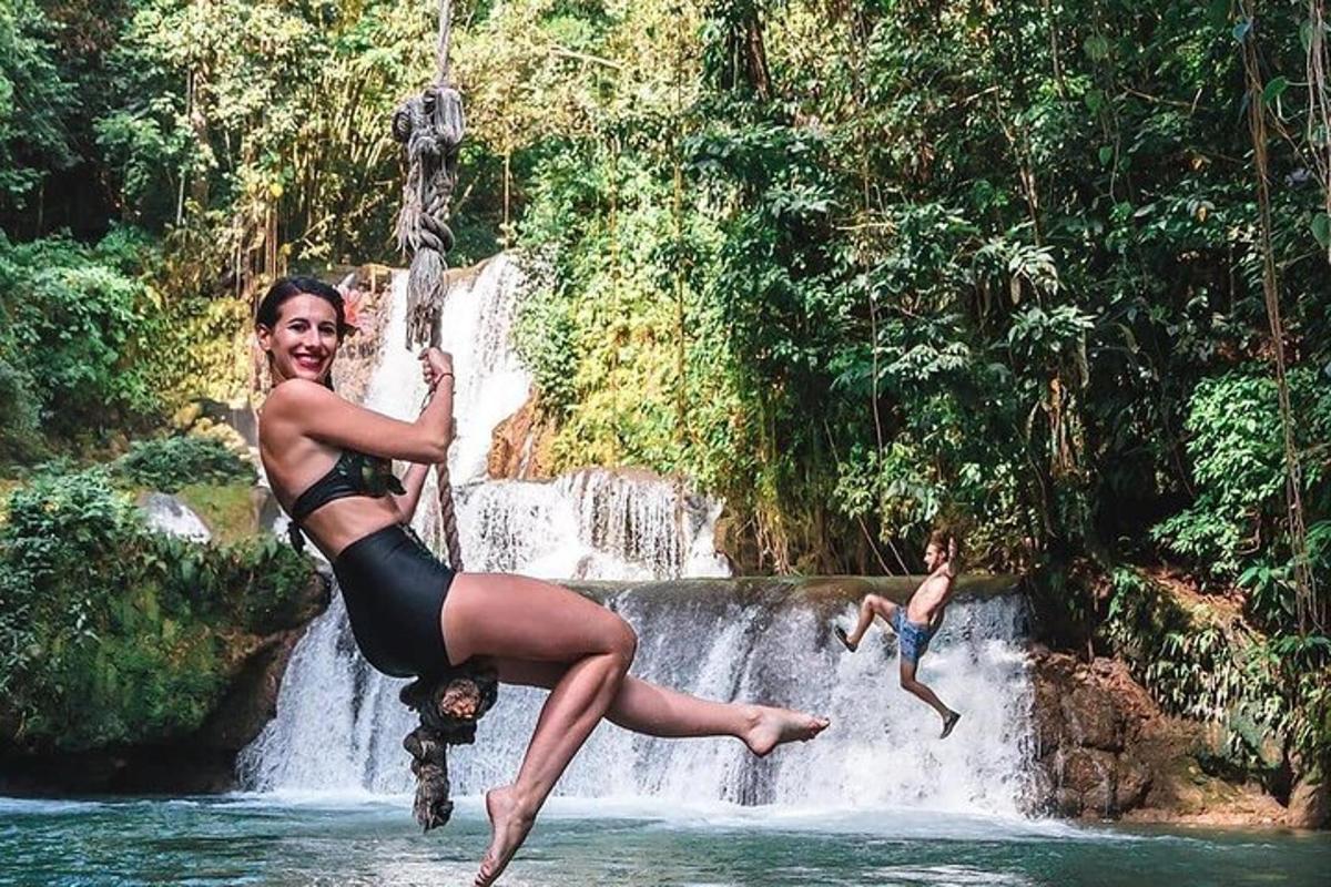 a woman jumping off of a waterfall in the water