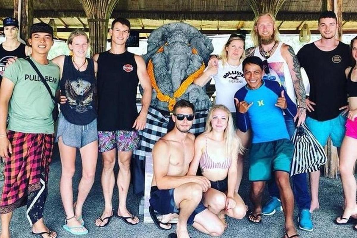 un gruppo di persone in posa davanti a una statua