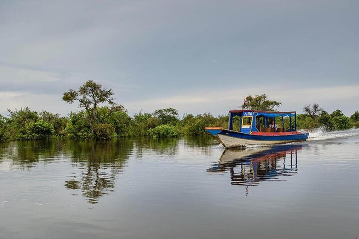 Un barco azul y rojo viajando por un río