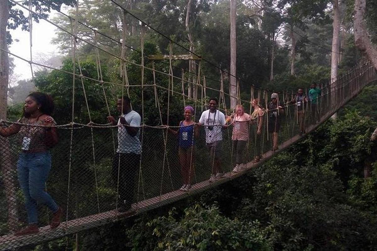 um grupo de pessoas em pé em uma ponte suspensa