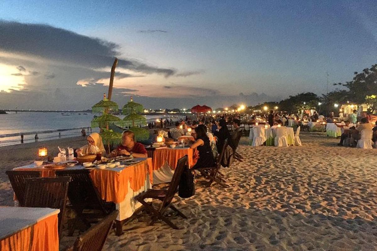 skupina ljudi, ki sedijo za mizami na plaži