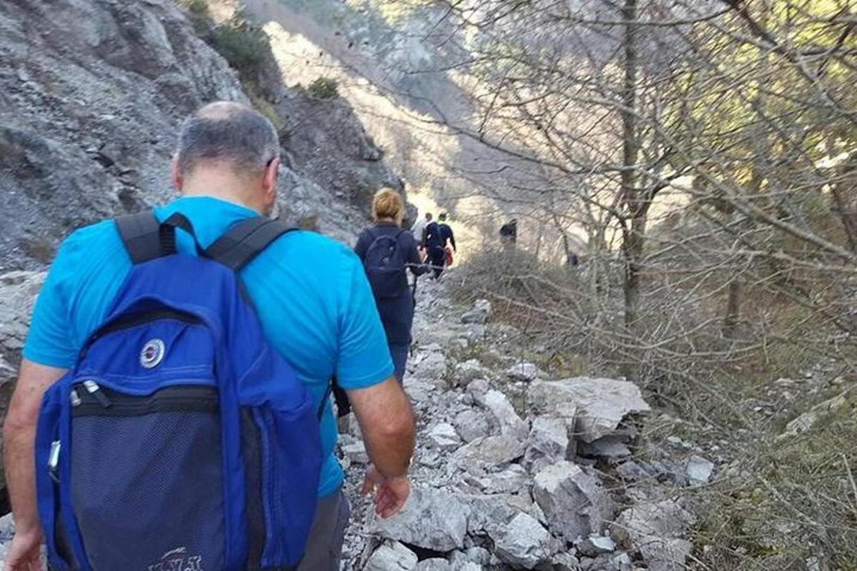 un uomo con uno zaino che cammina lungo un sentiero roccioso