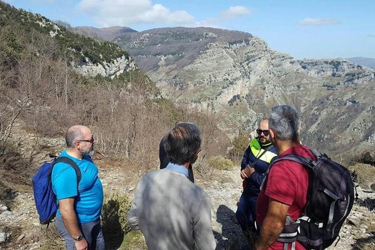 un gruppo di uomini in piedi sulla cima di una montagna