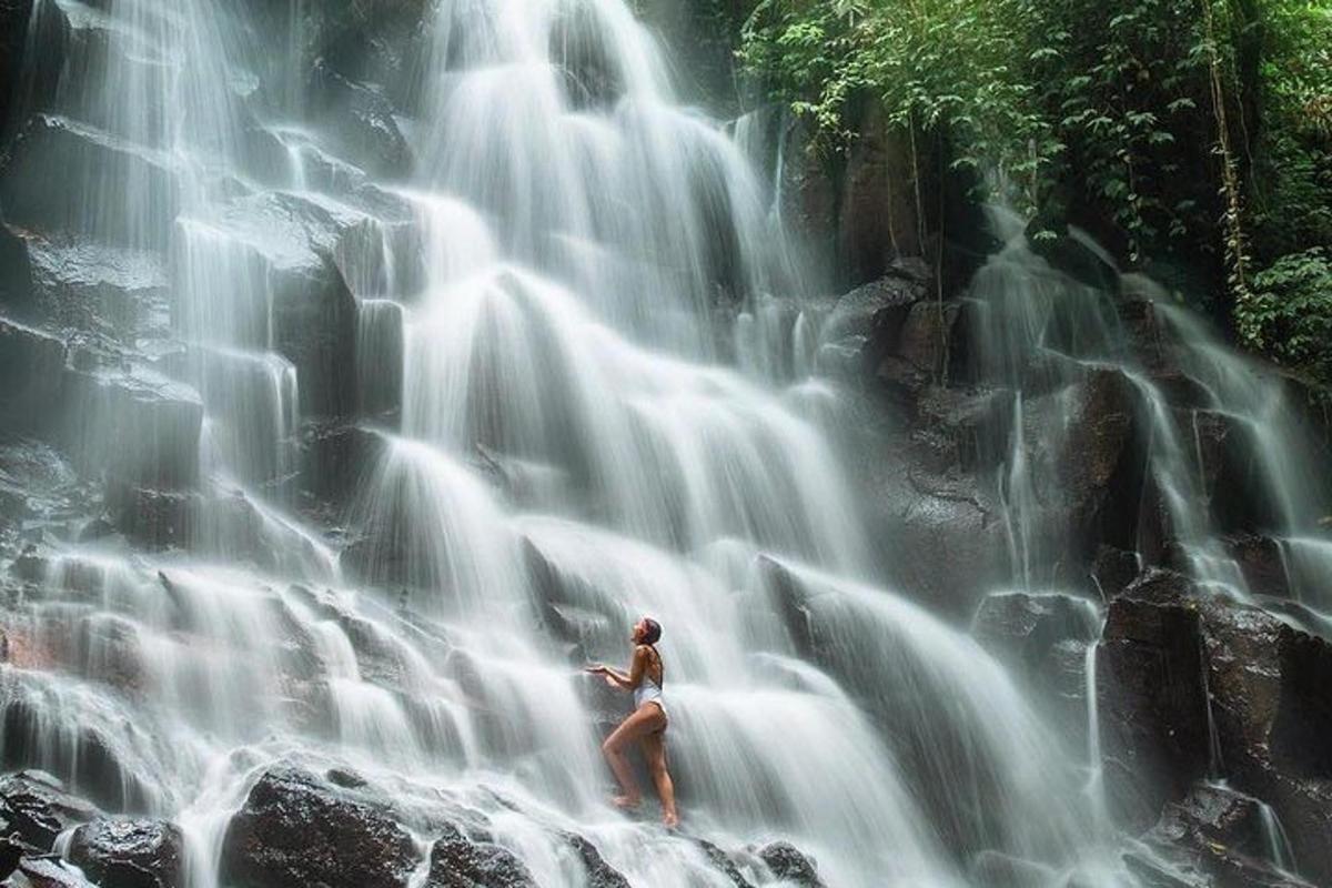 uma mulher parada em frente a uma cachoeira