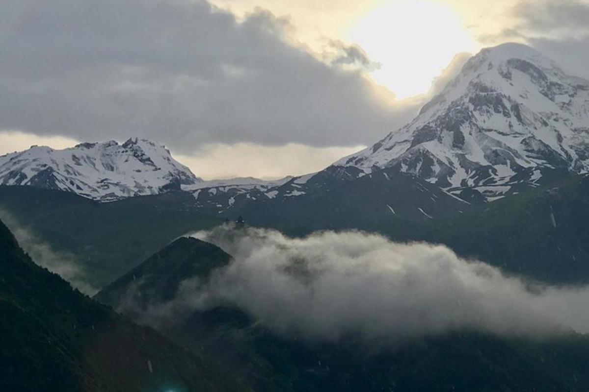una montagna coperta di neve con nuvole di fronte