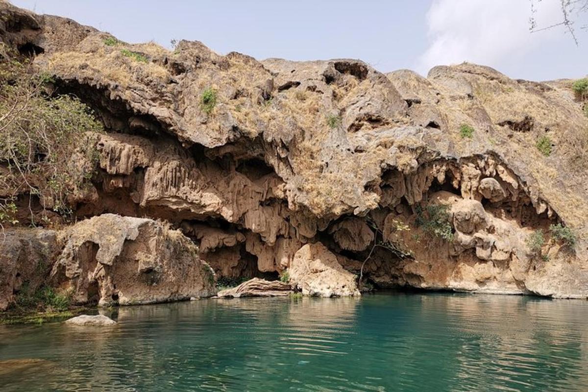 a body of water next to a rocky cliff