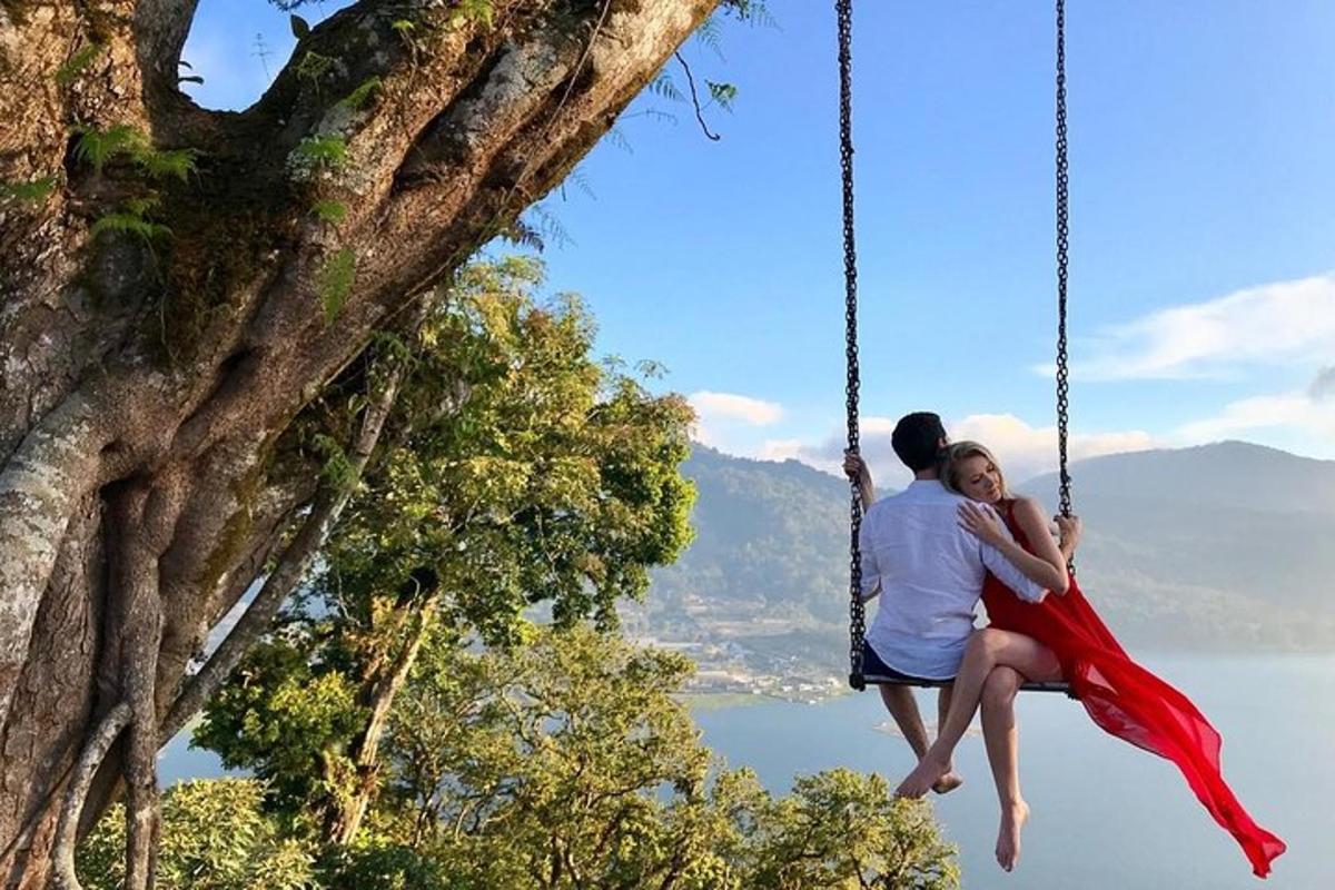 a man and woman sitting on a swing in a tree