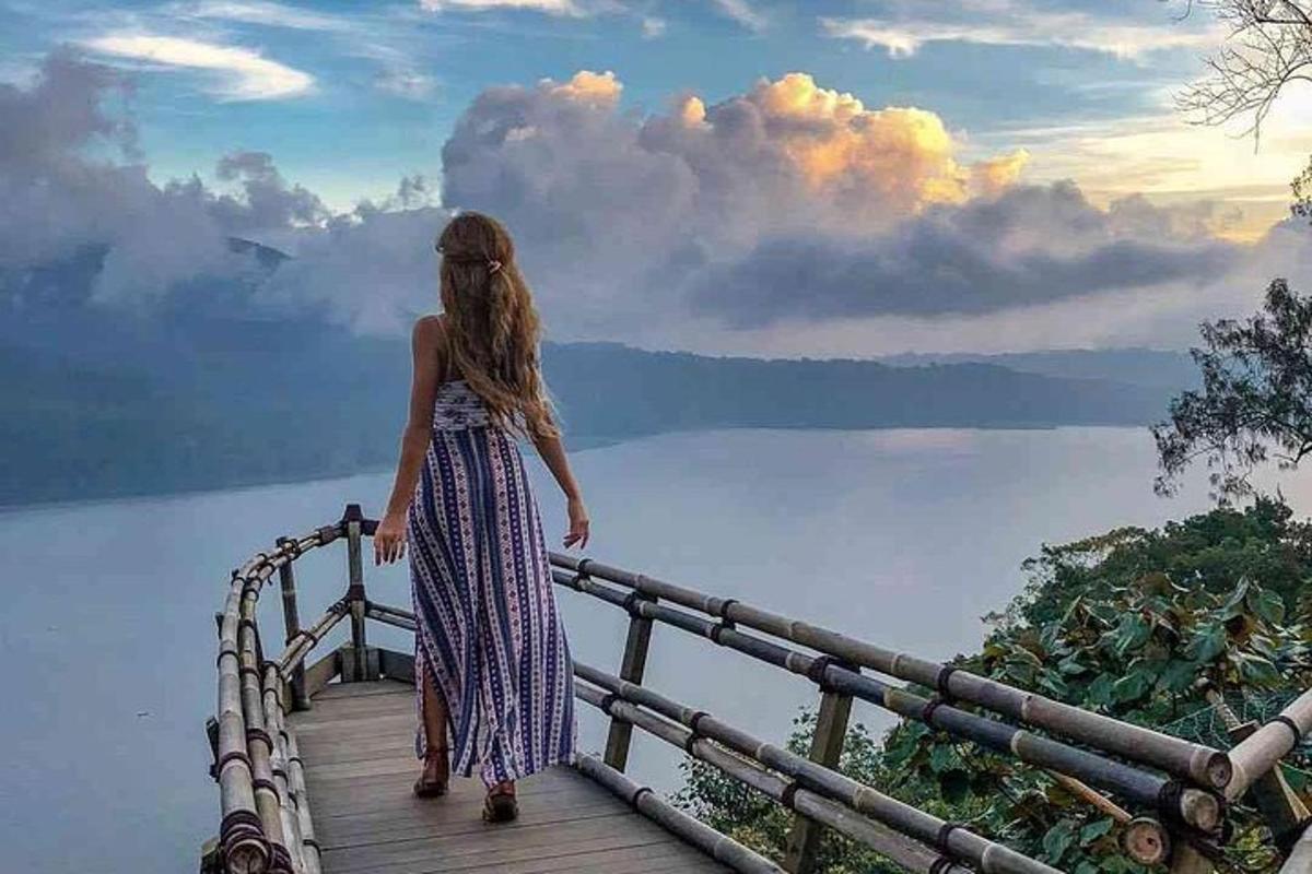 a woman standing on a bridge over a body of water