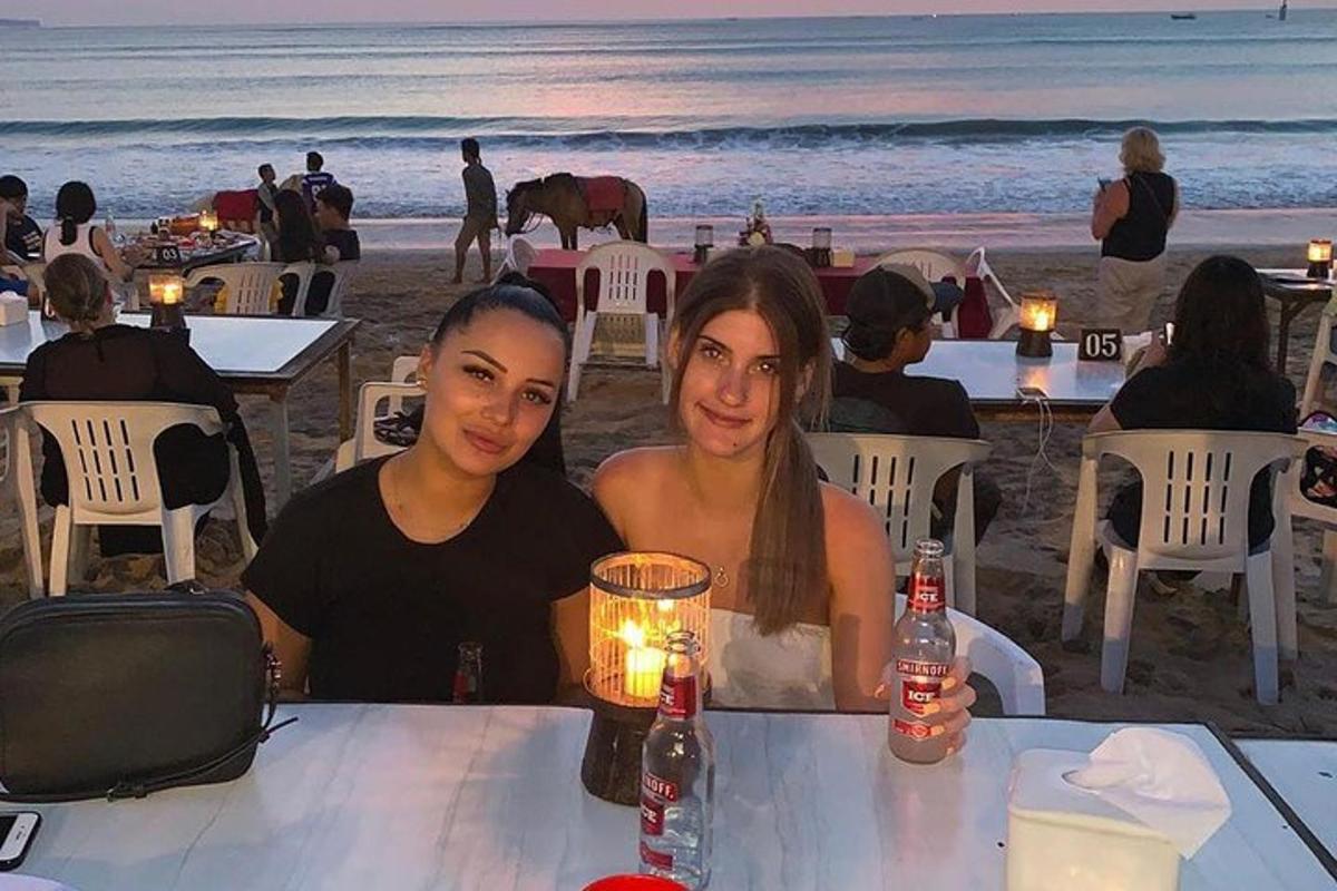 dua wanita duduk di meja di pantai