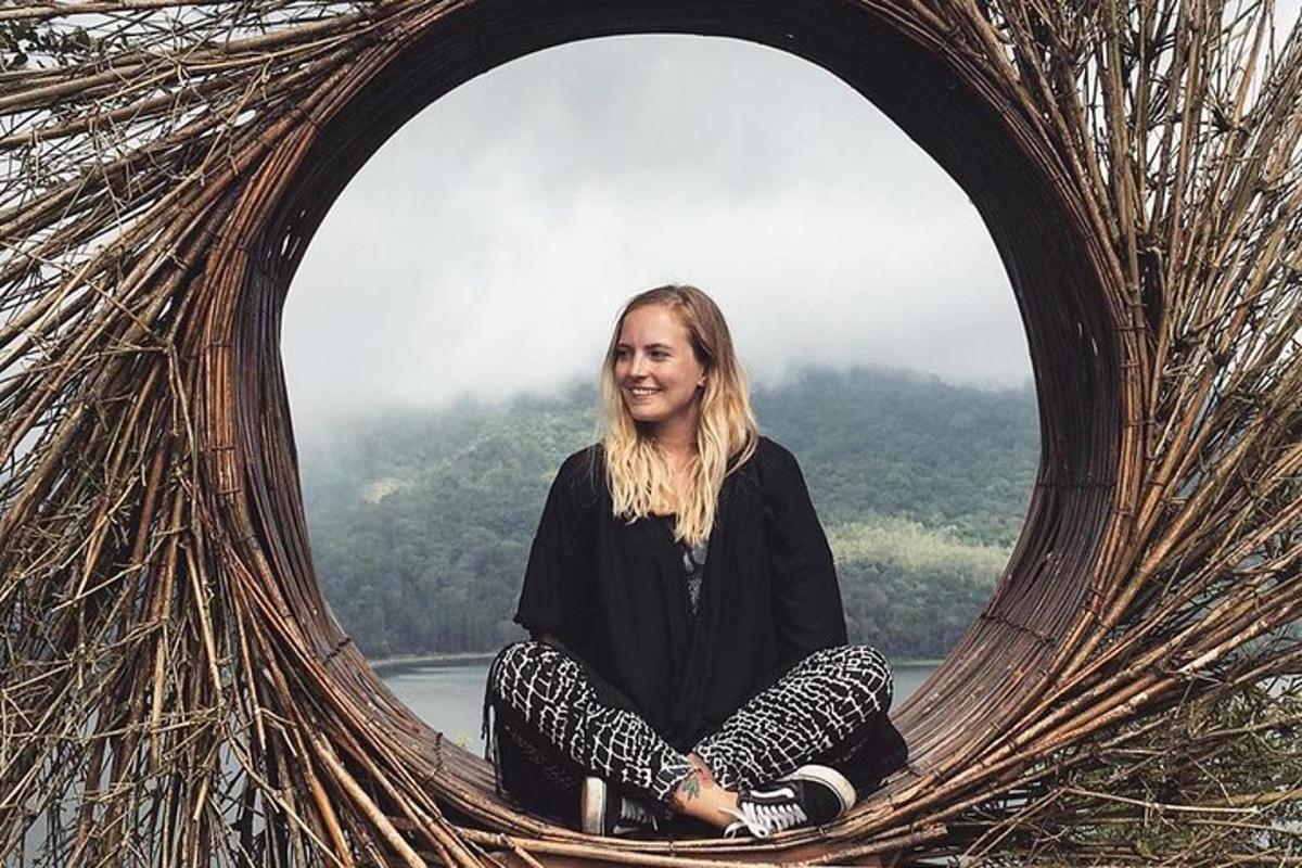 a woman is sitting in a round mirror