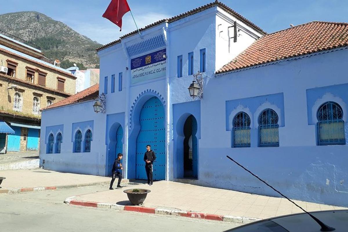a blue building with a man standing in front of it