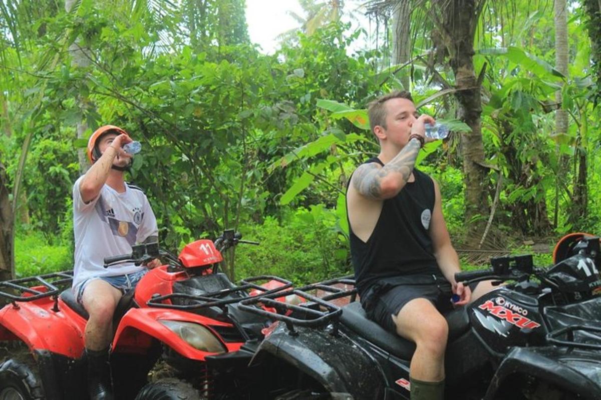 zwei Männer trinken Wasser aus Wasserflaschen auf einem Motorrad