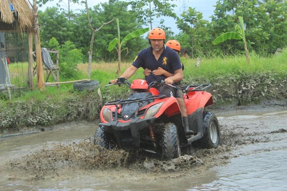 ein Mann, der mit einem Quad durch den Schlamm fährt