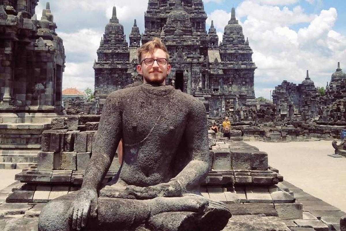 een man zittend in een standbeeld voor een tempel