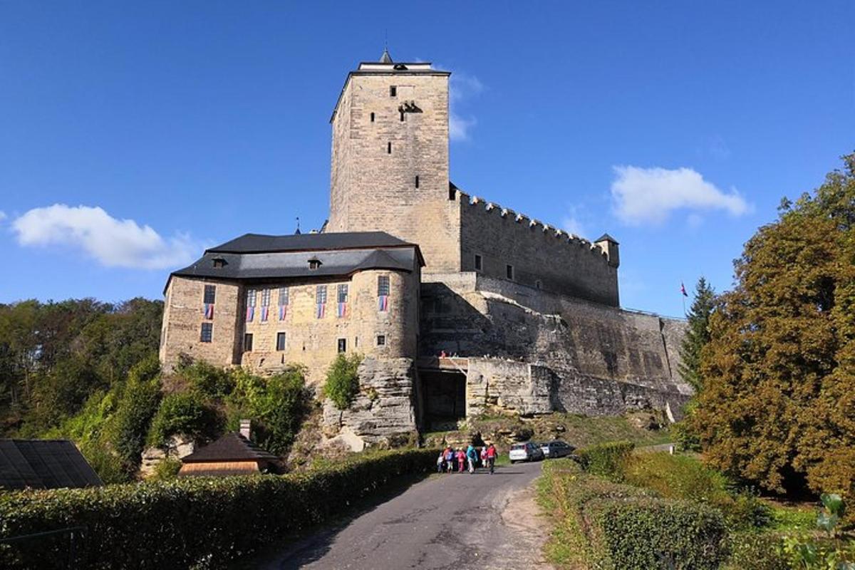 un gruppo di persone che camminano lungo una strada di fronte a un castello