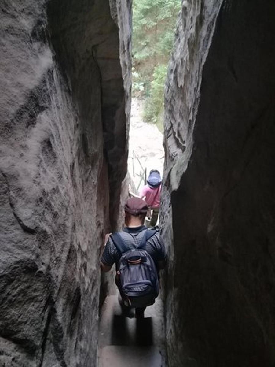 due persone che camminano lungo uno stretto sentiero in una grotta