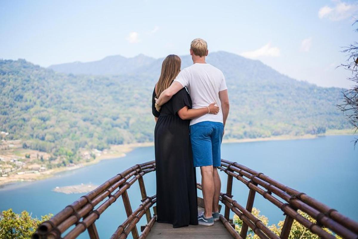 un uomo e una donna in piedi su un ponte che domina un lago