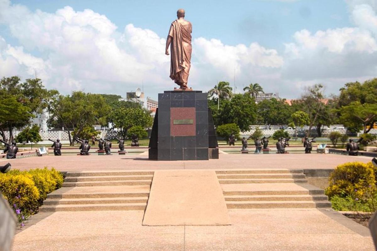 una statua di un uomo su un piedistallo in un parco
