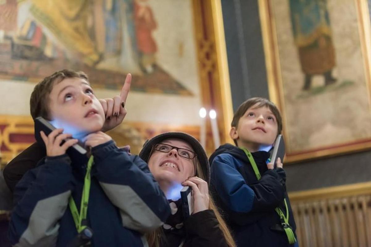 a group of three children holding up their cell phones