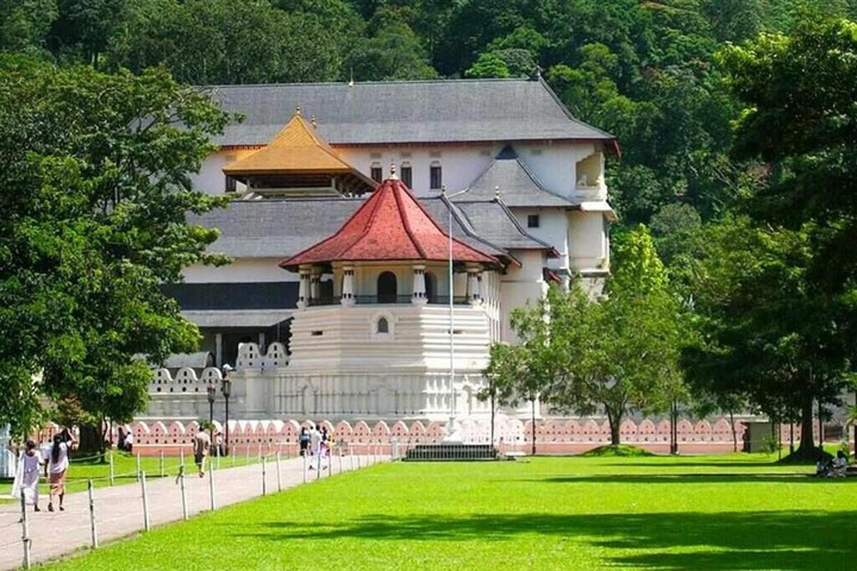 a large white building with a red roof in a park
