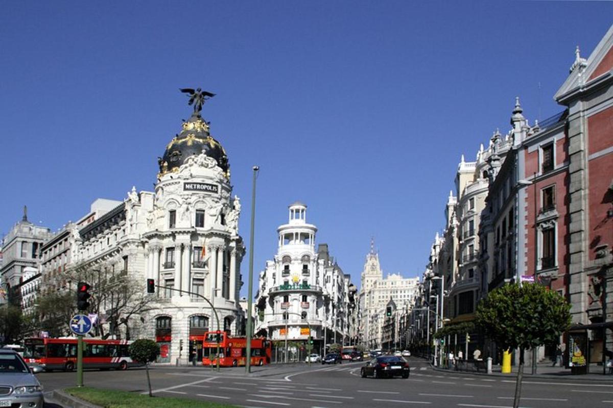 un carrer de la ciutat amb un edifici amb una estàtua a sobre