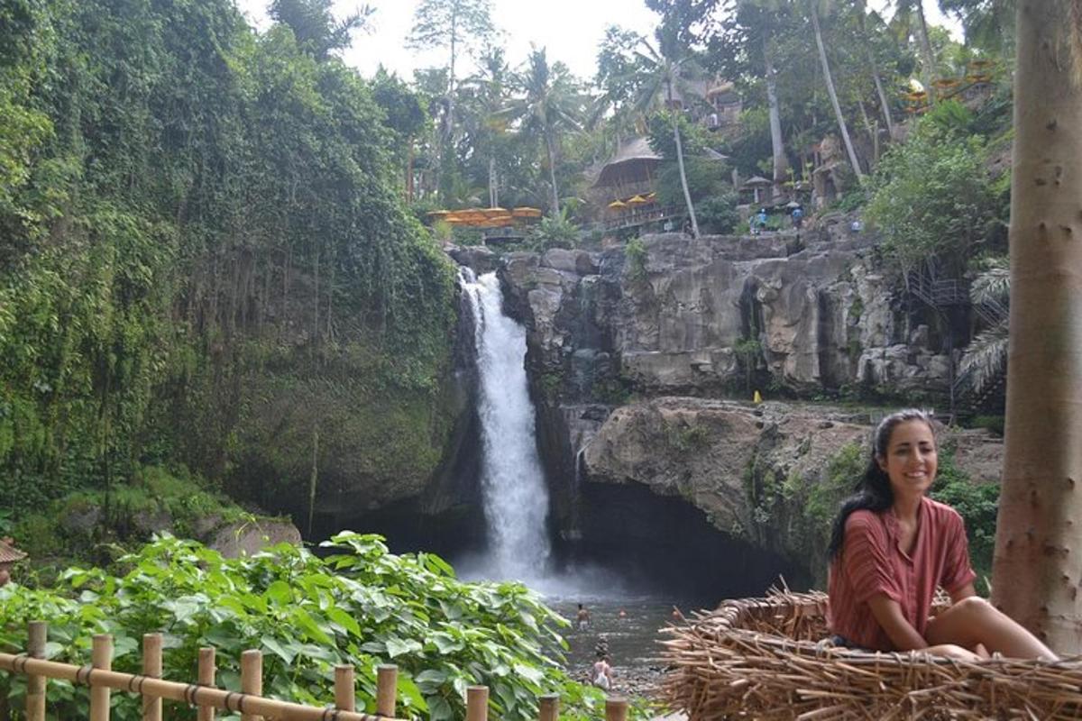 seorang wanita duduk di depan air terjun