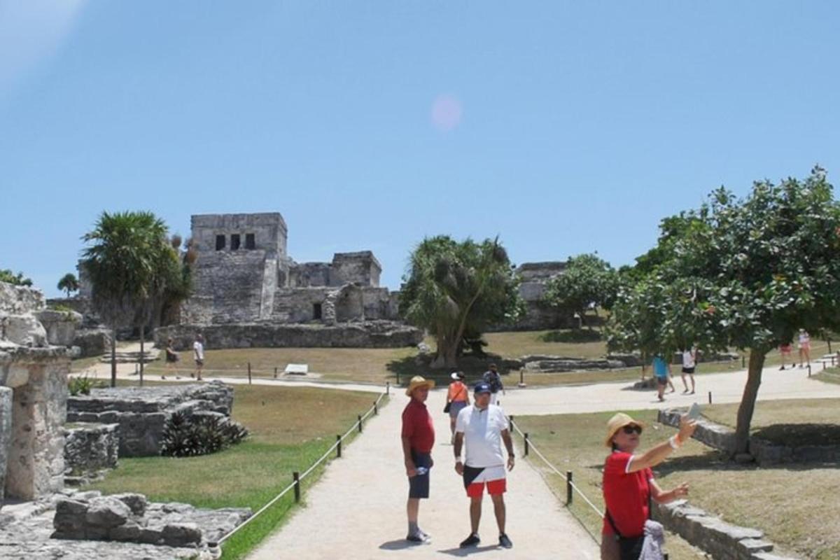 Un grupo de personas de pie junto a las ruinas.