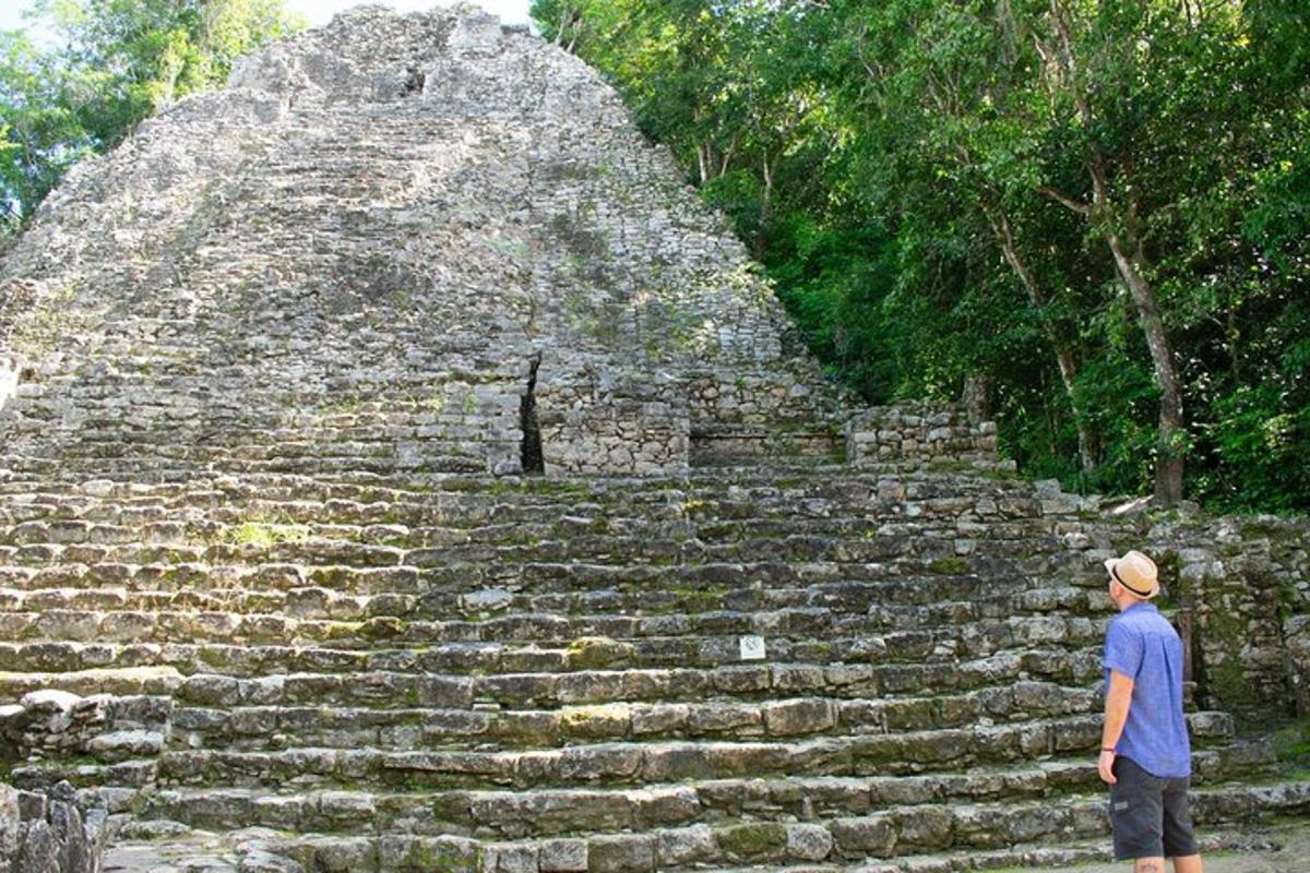 a man standing in front of a pyramid