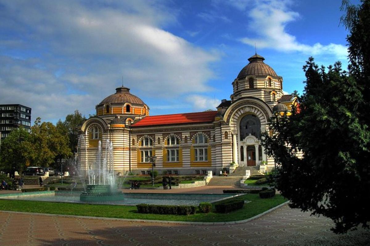 un grande edificio con una fontana di fronte