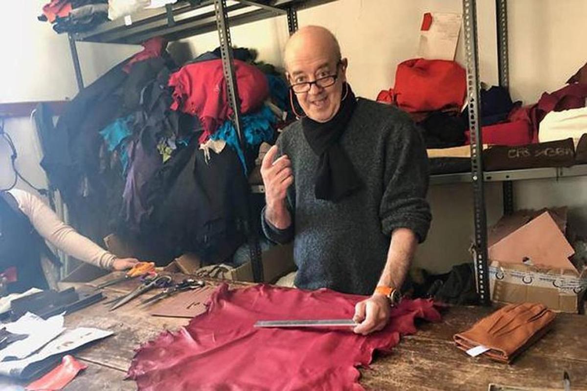 un uomo seduto a un tavolo che taglia un vestito rosso