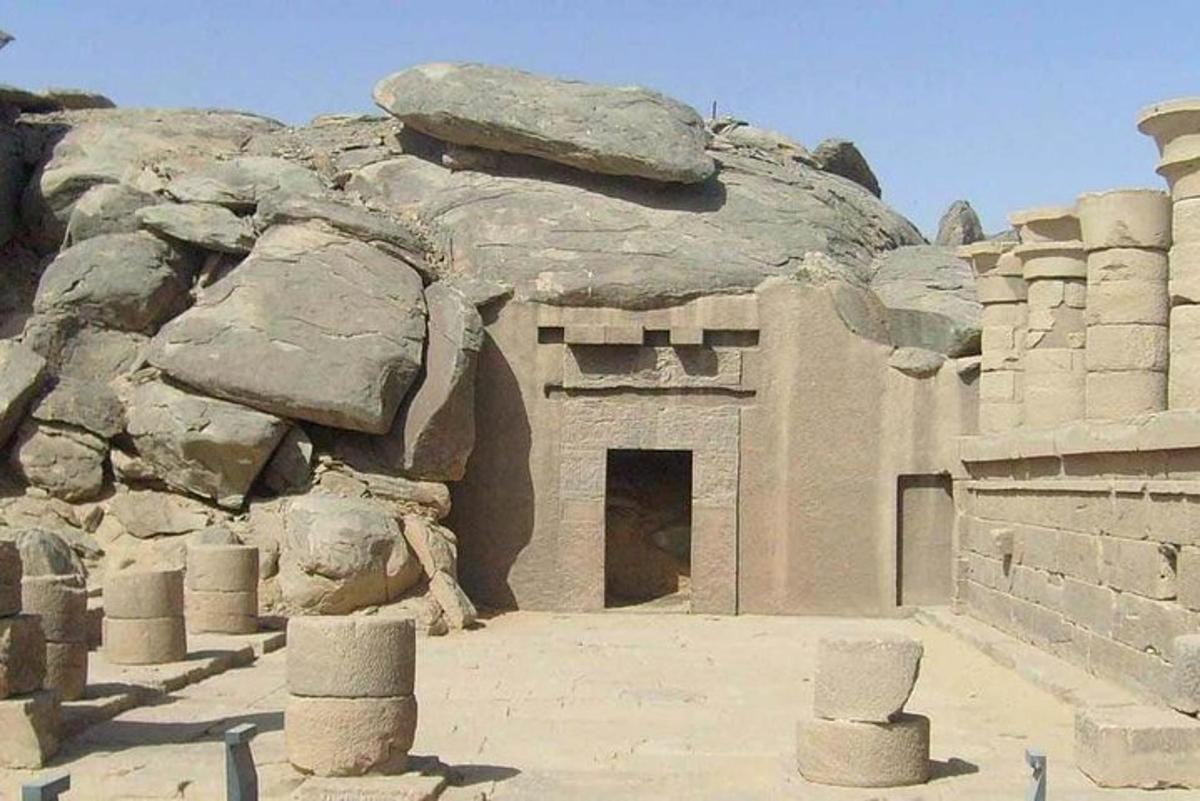 un edificio in pietra con una grande roccia
