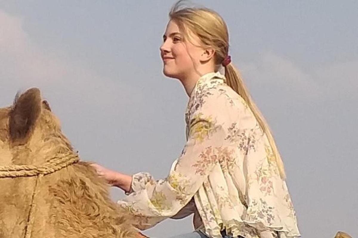 una donna in piedi accanto alla statua di un cavallo