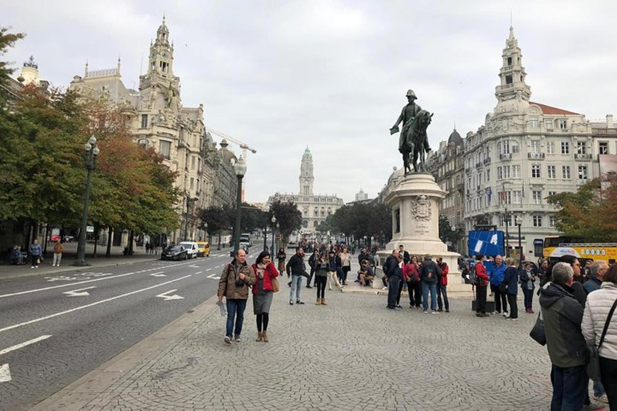 um grupo de pessoas em pé ao redor de uma estátua em uma rua da cidade