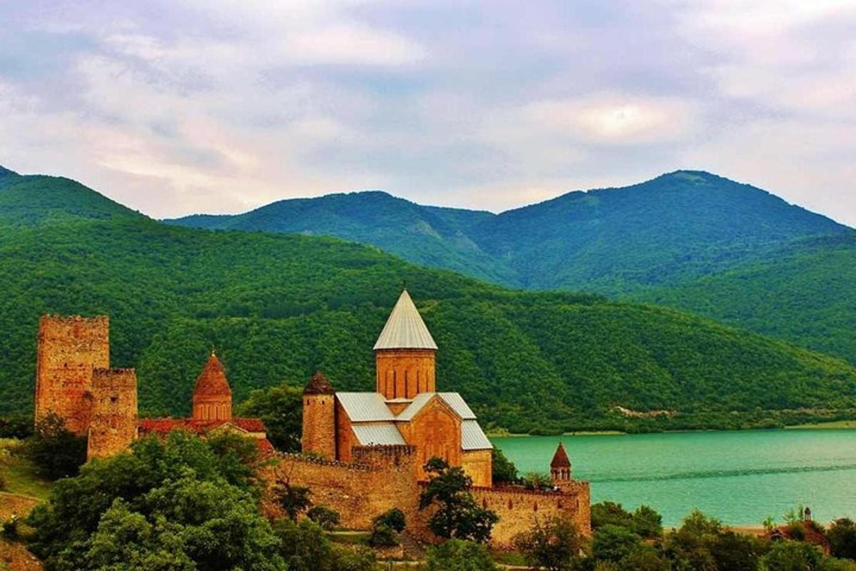 un castell en un turó al costat d'una massa d'aigua