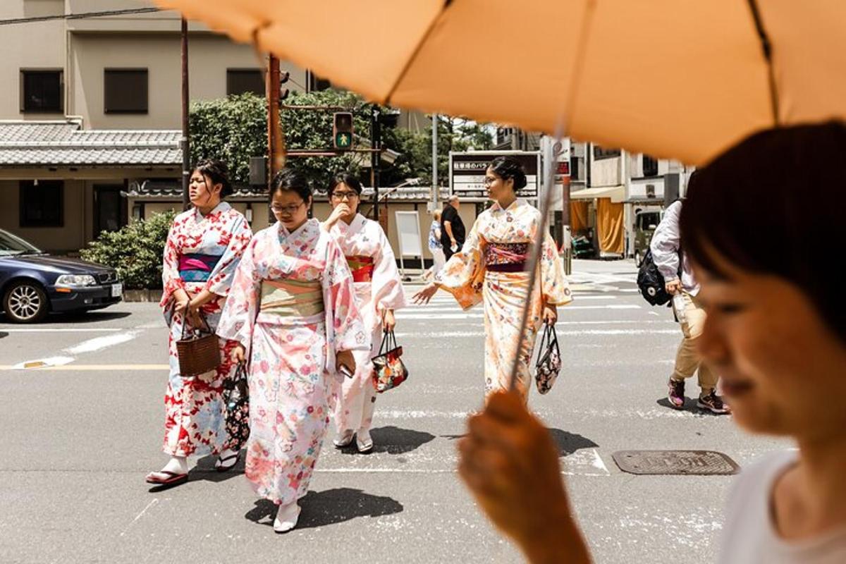 eine Gruppe von Frauen in Kimonos, die eine Straße entlang gehen