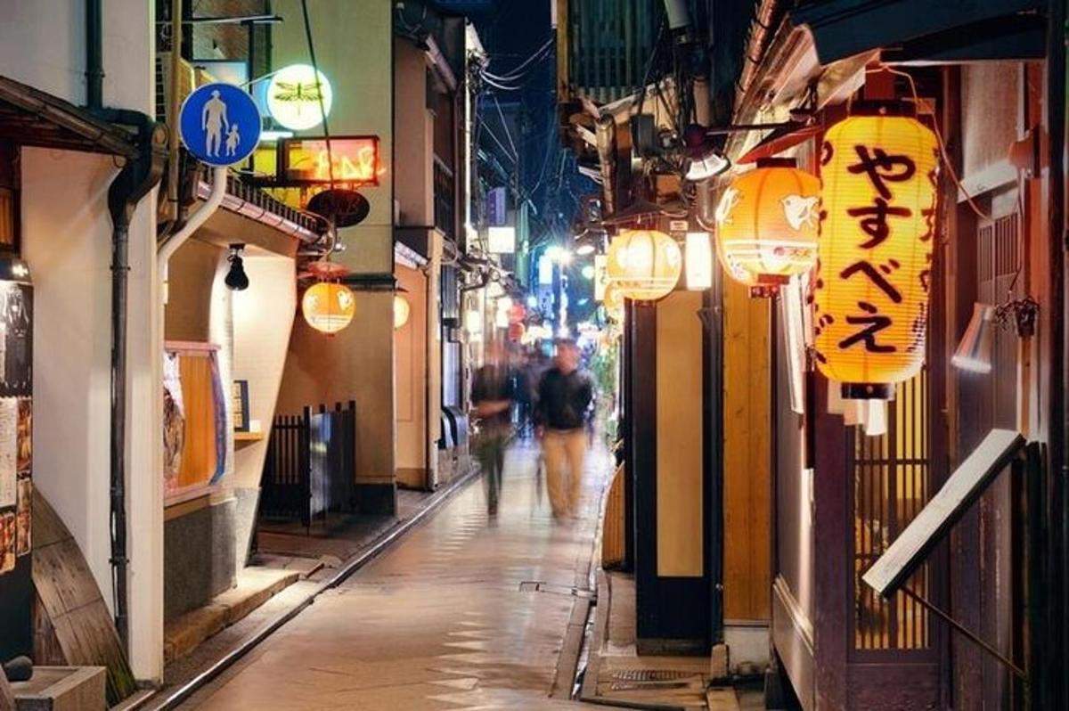 un paio di persone camminano lungo una strada di notte