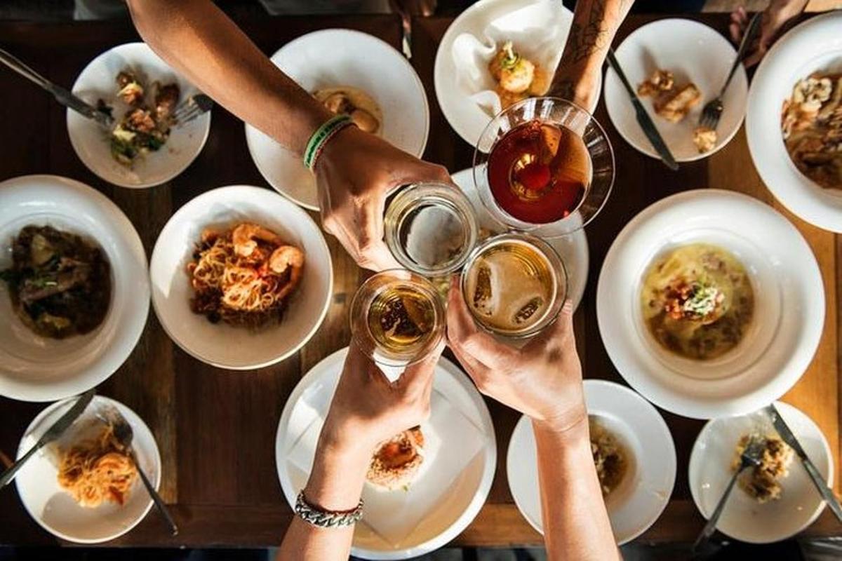 a group of people drinking wine at a table with plates of food
