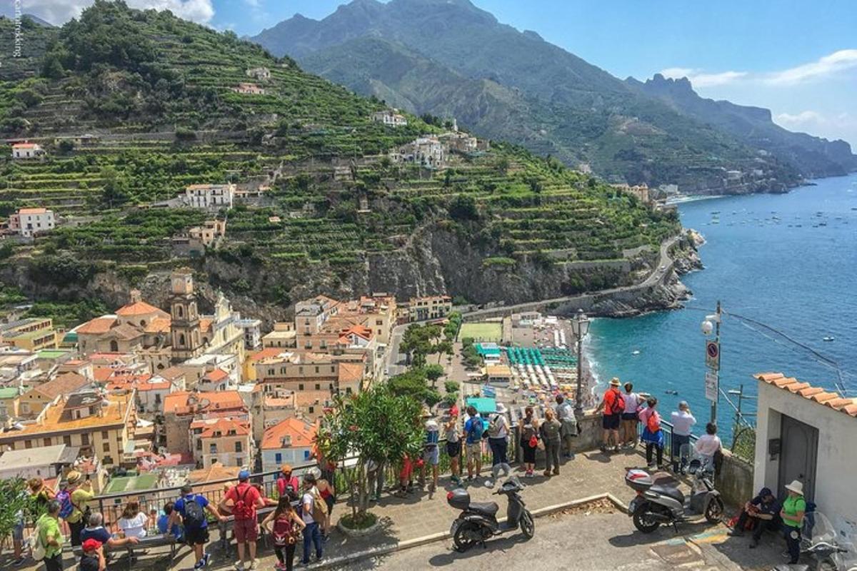 un gruppo di persone in piedi su una collina vicino all'acqua